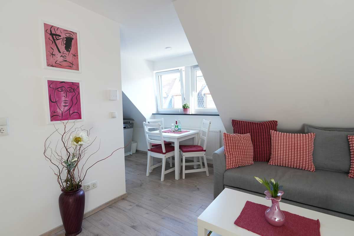 Ess- und Wohnbereich mit gemütlicher Sitzecke und Esstisch in der Ferienwohnung GoJa unter dem Dach