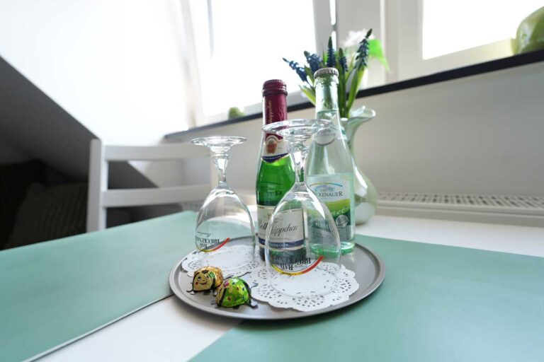 Freundlicher Willkommensgruß mit Gläsern und Getränken auf dem Tisch