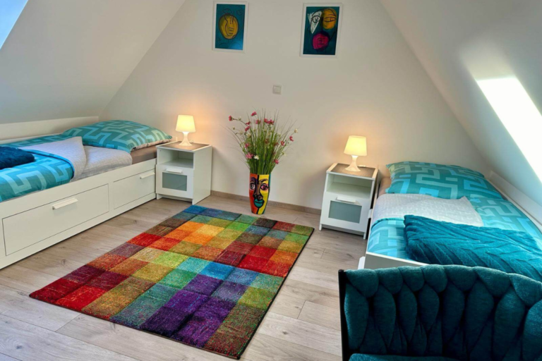 Schlafzimmer mit zwei Einzelbetten unter dem Dach in heller Ferienwohnung