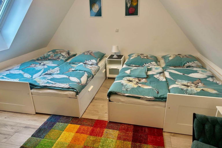 Schlafzimmer mit zwei ausziehbaren Einzelbetten unter dem Dach in heller Ferienwohnung