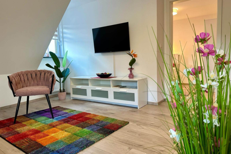 TV-Bereich mit Sideboard, Wandfernseher und Dekoration in der Ferienwohnung GoJa