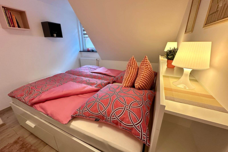 Helles Schlafzimmer mit Doppelbett und Stauraum in der Ferienwohnung GoJa
